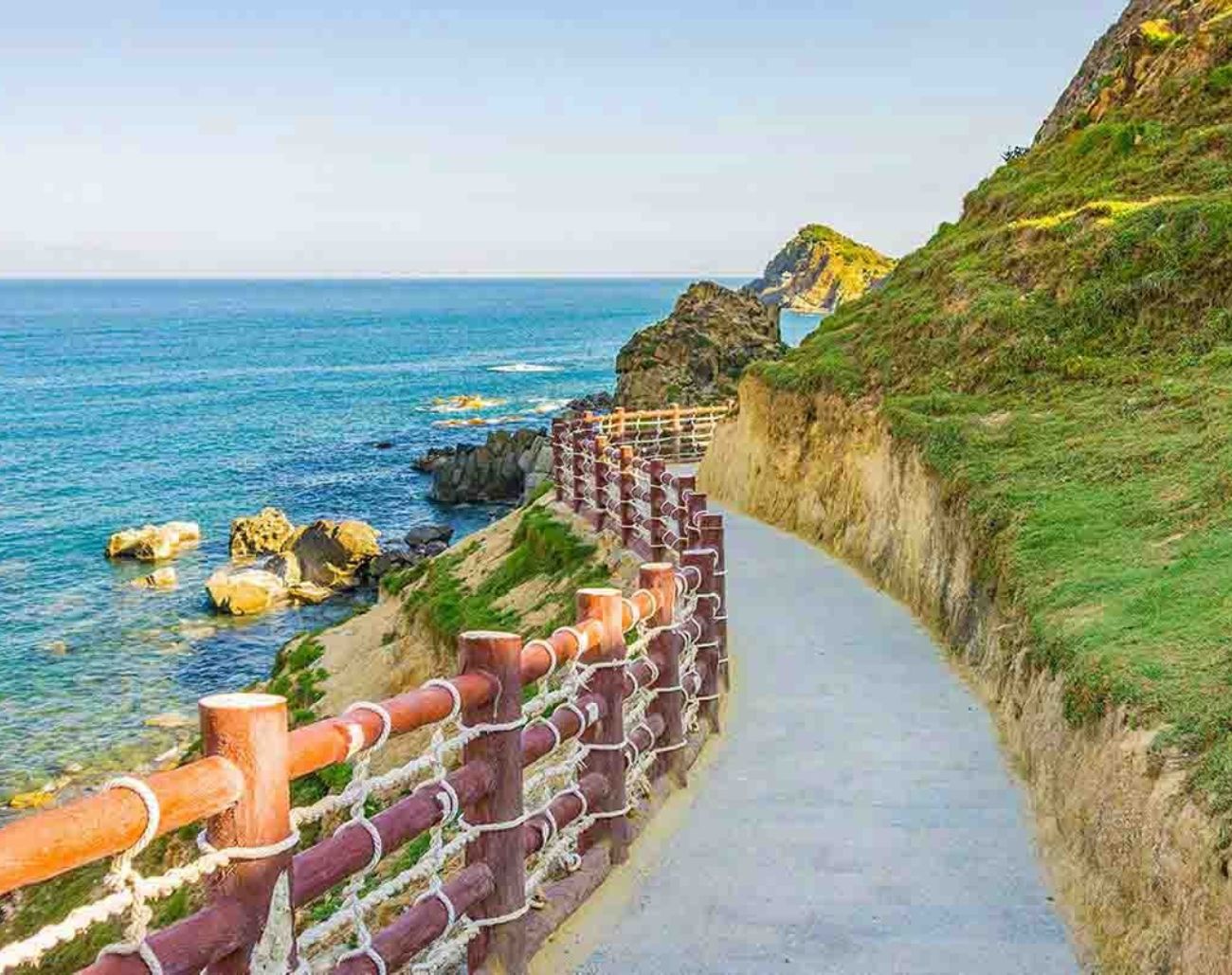 Con đường ven biển Eo Gió Quy Nhơn với lan can đỏ trắng đặc trưng – địa điểm check-in được yêu thích bởi vẻ đẹp hoang sơ và cảnh biển xanh biếc.